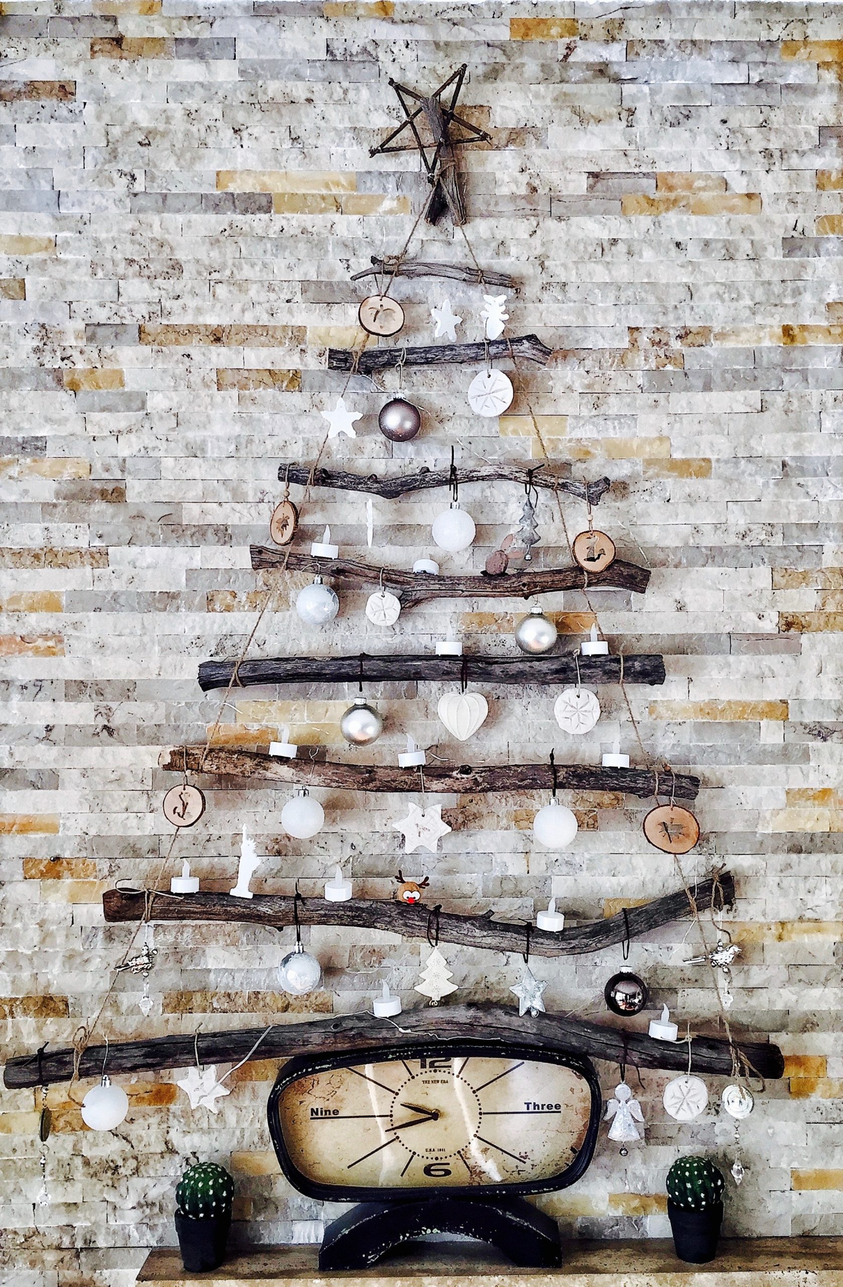 A Christmas tree wall decor A Christmas wall décor using tree branches and decorative elements.