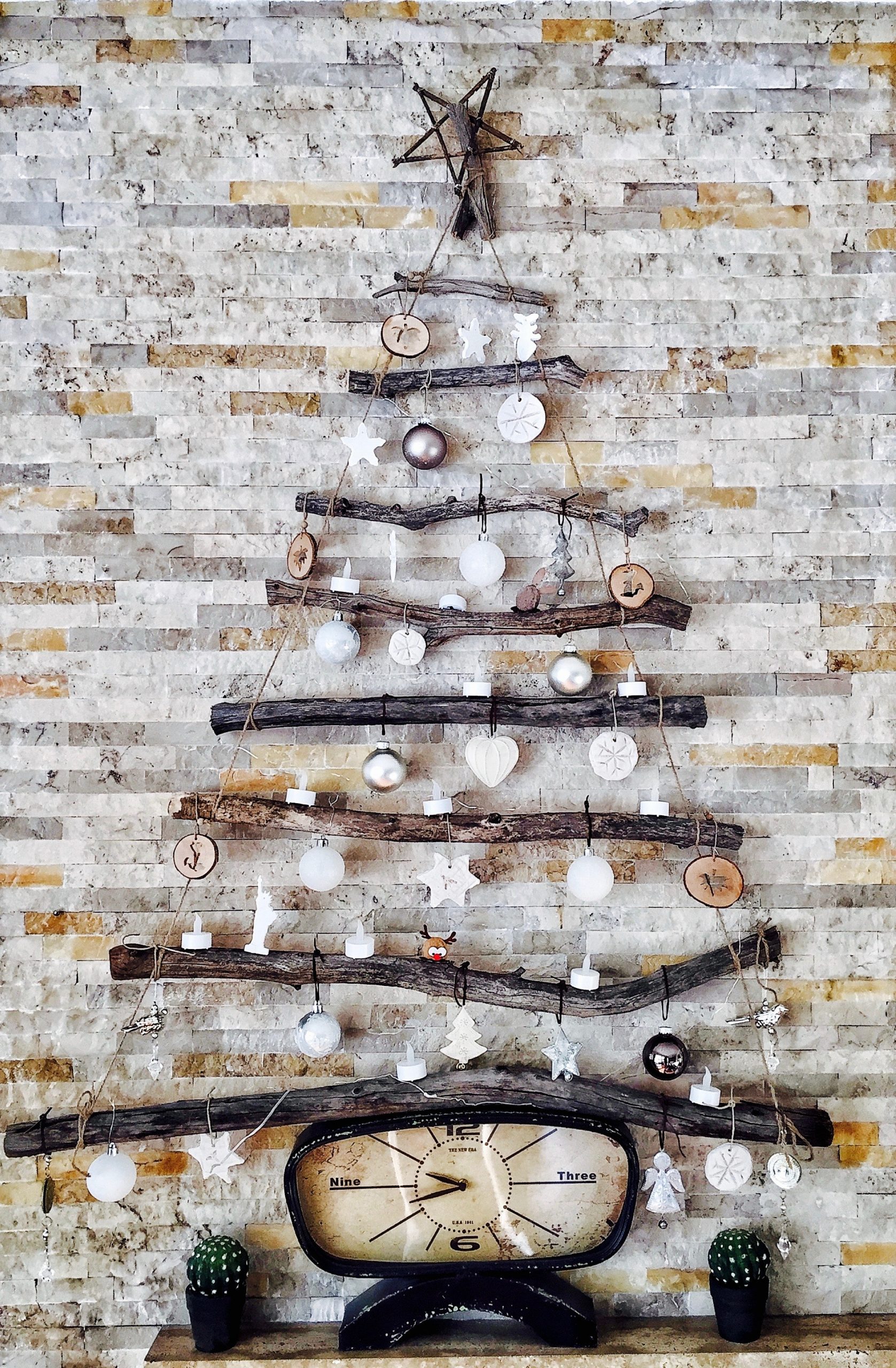 A Christmas wall décor using tree branches and decorative elements.