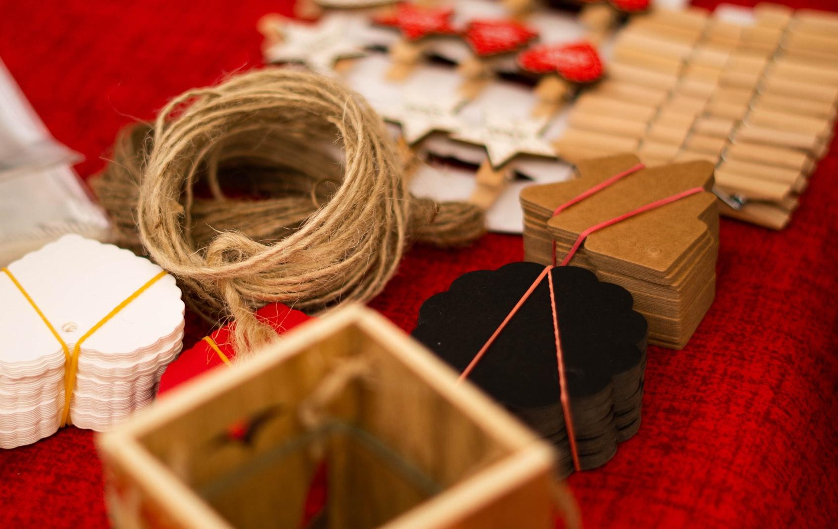 ball of twine and crafts Different kinds of art and craft materials placed on a red fabric.
