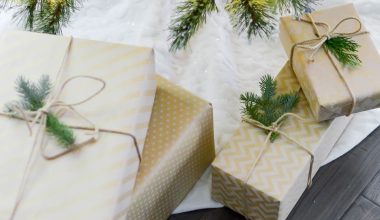 A Christmas tree with ornaments and lights and gifts boxes placed below