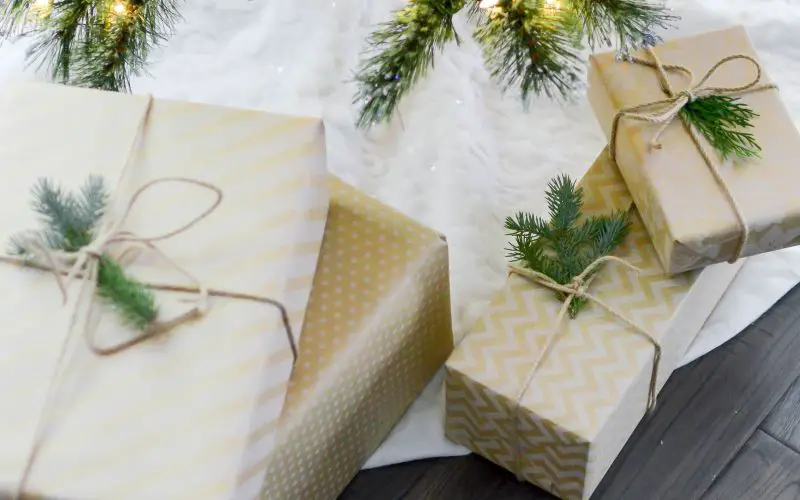 A Christmas tree with ornaments and lights and gifts boxes placed below