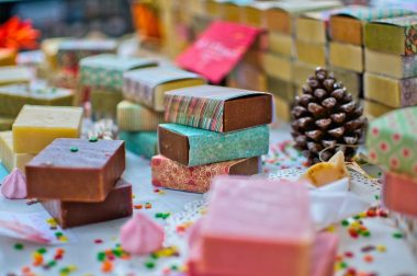 Numerous different kinds of handmade soaps placed together in a colorful setting.