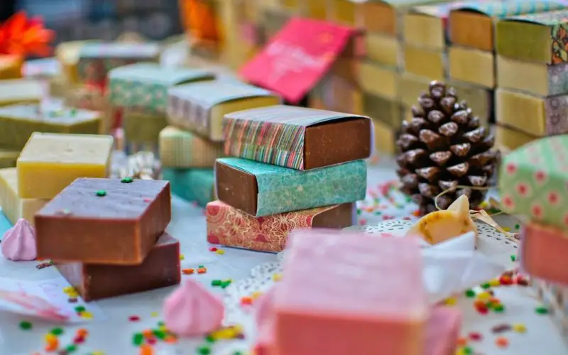 Numerous different kinds of handmade soaps placed together in a colorful setting.