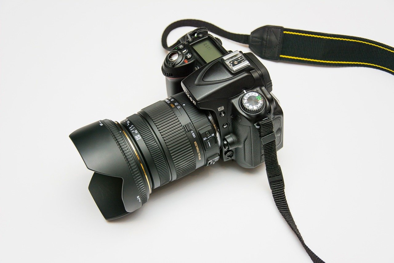 A digital camera with multiple lenses and a neck strap