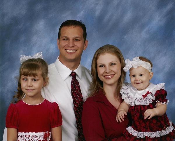 Family portrait of a father, mother, a girl and a baby.