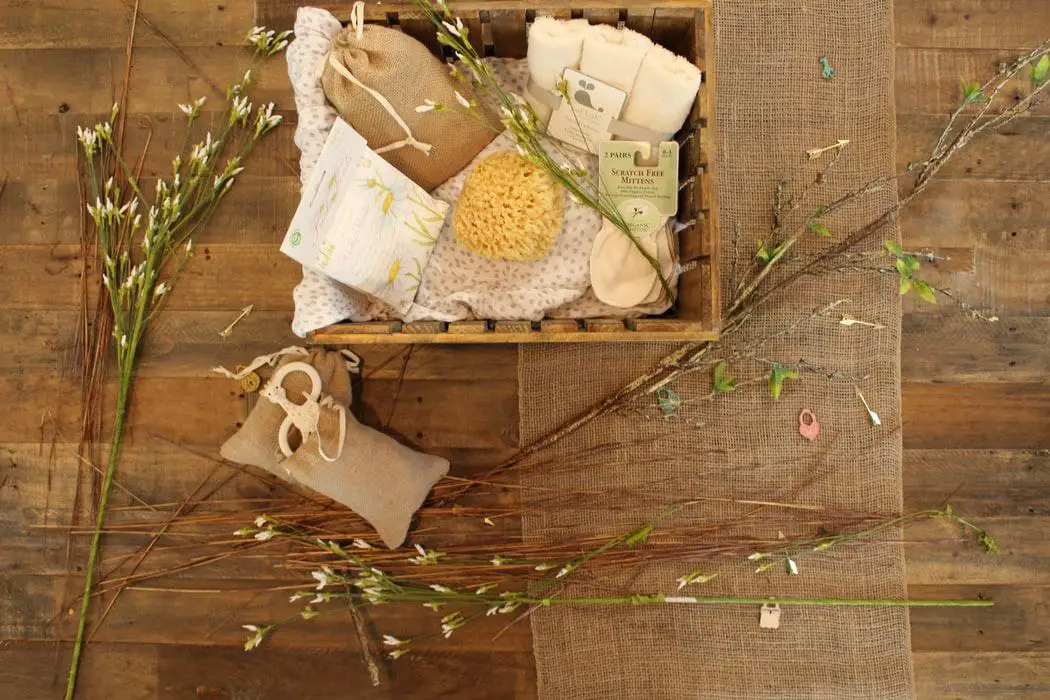 Spa gift box with many elements A spa gift box along with some weeds kept in a wooden basket on a wooden surface.