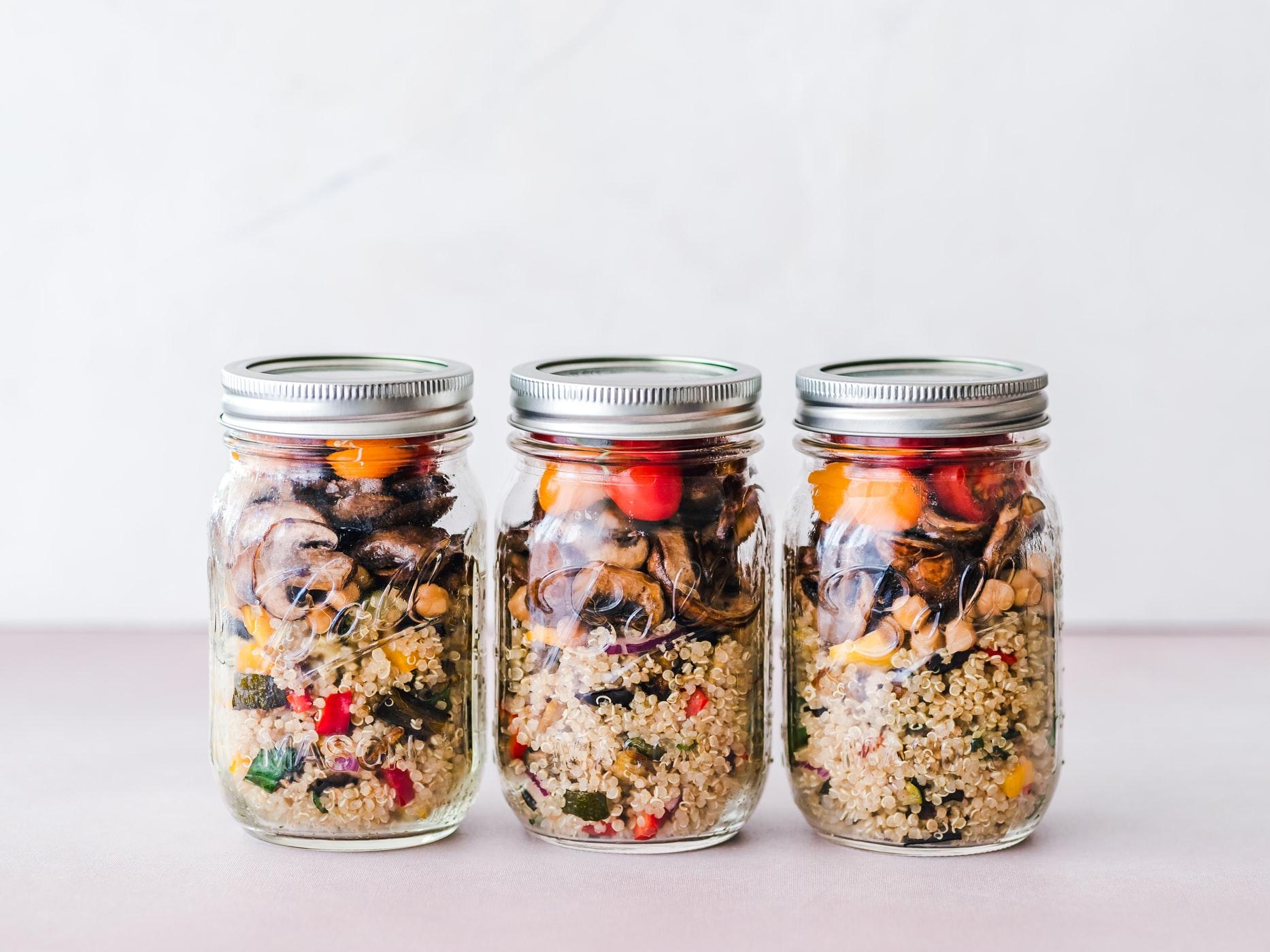 Three full mason jars kept on a plain surface.