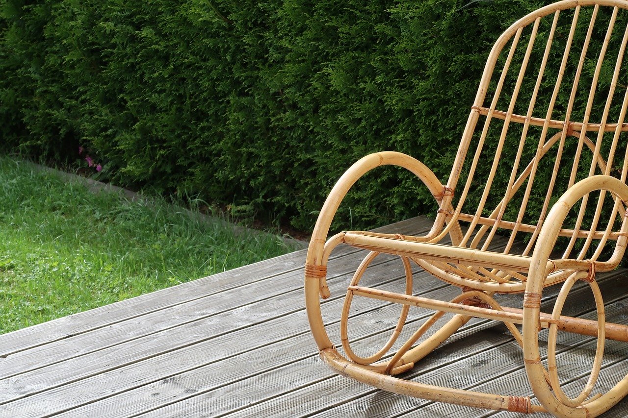 A wooden rocking chair on top of a garden deck