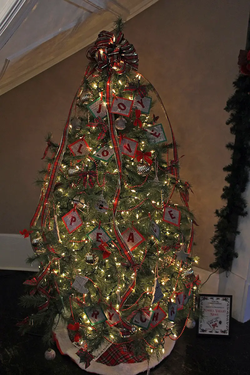 A Christmas tree featuring decorative lights, plaid, and messages that capture the Christmas spirit.