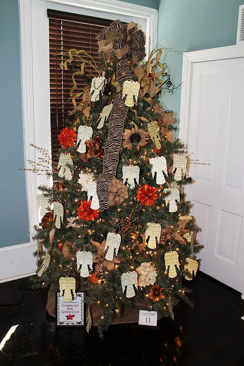 A Christmas tree decorated using a variety of red and brown flowers and other decorative elements that give it a rustic charm.