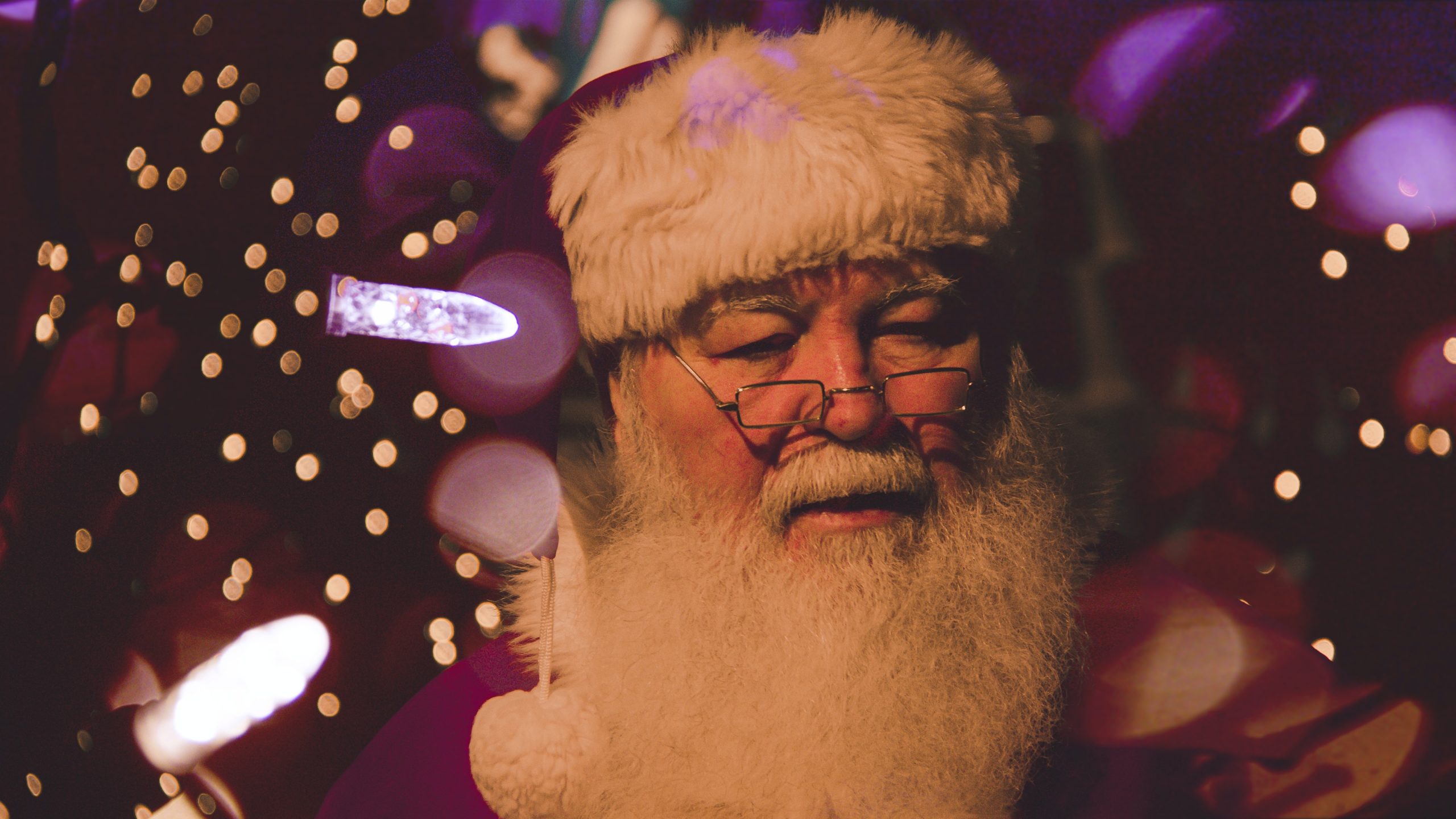 A man dressed up as Santa Claus surrounded by Christmas-themed decorations
