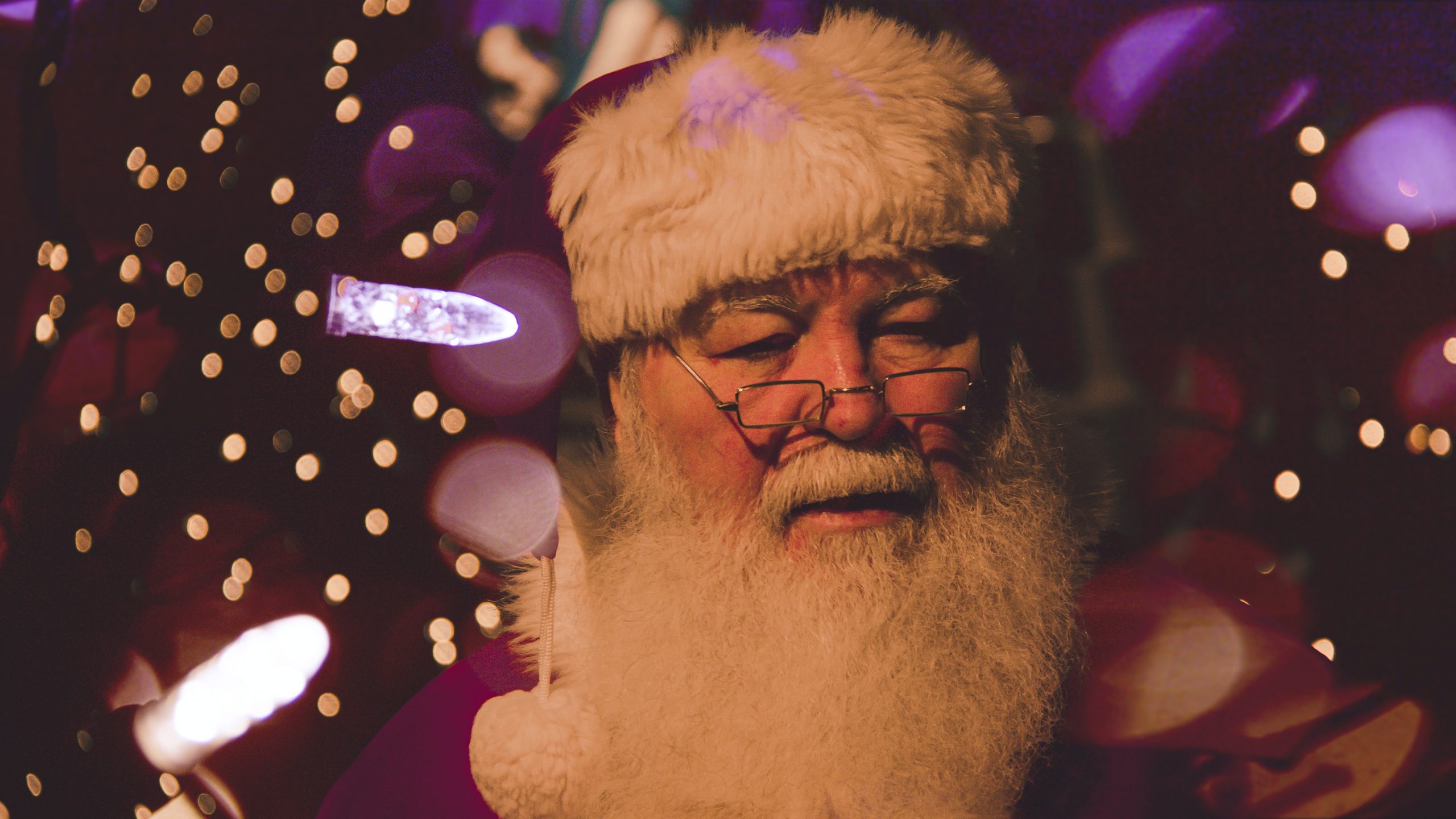 A man dressed up as santa claus A man dressed up as Santa Claus surrounded by Christmas-themed decorations
