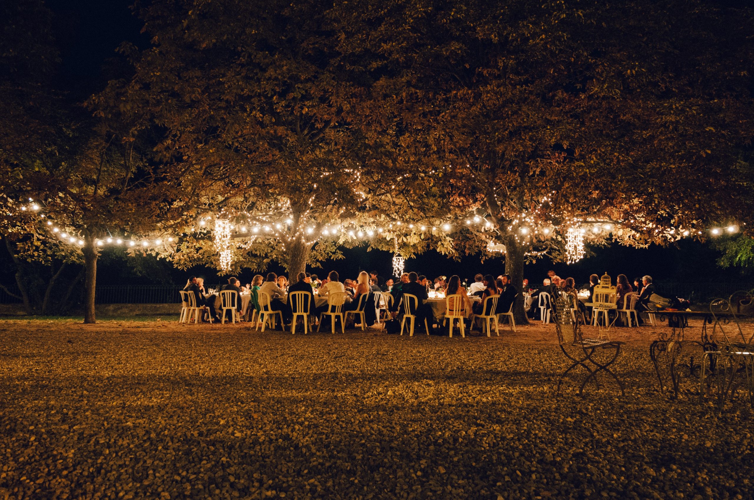 An outdoor wedding venue with lighting during the evening