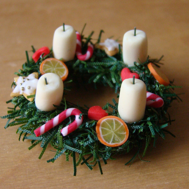 An edible Christmas wreath with candy canes, orange slices, and candles