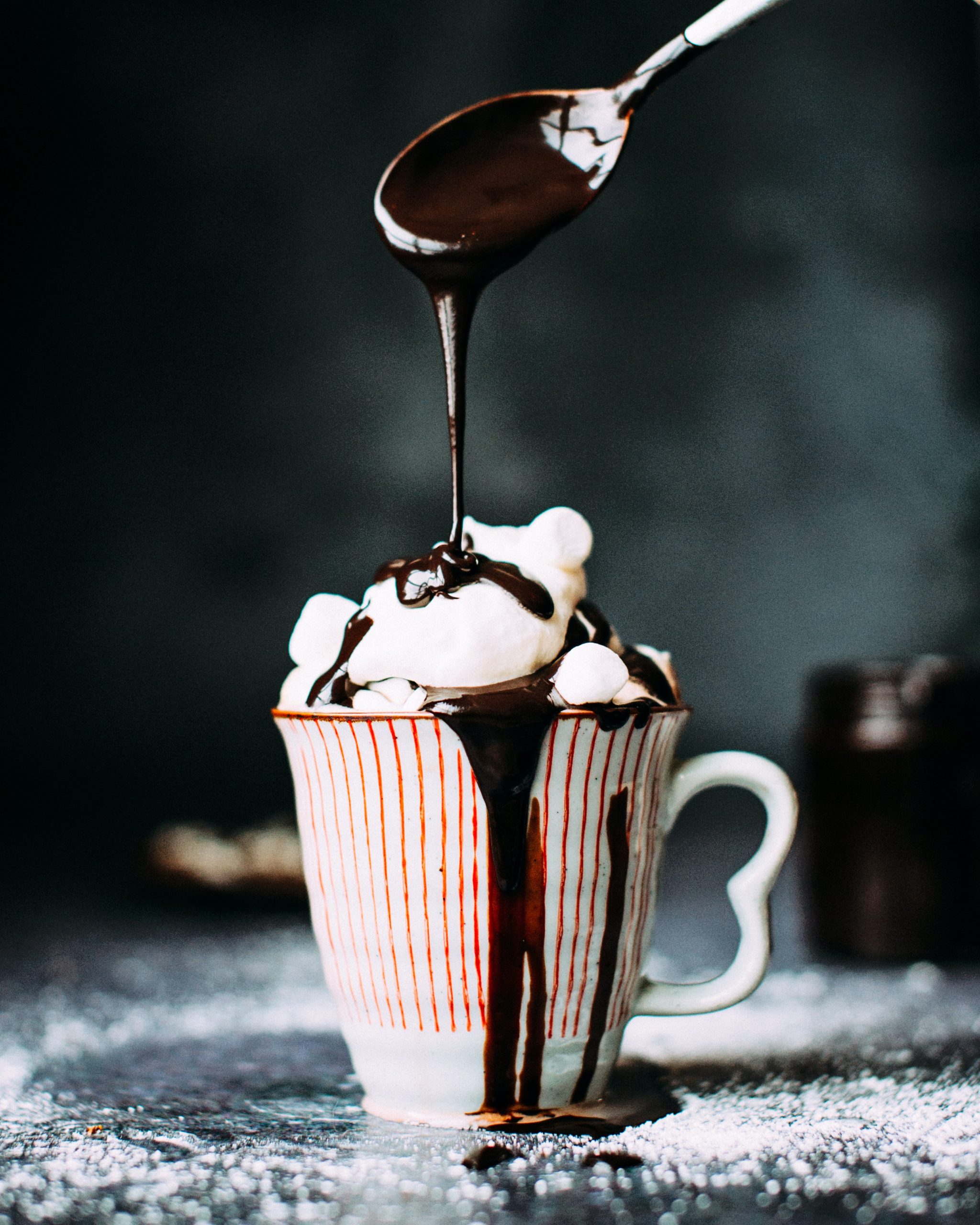 A wallpaper of chocolate syrup being poured over a mug