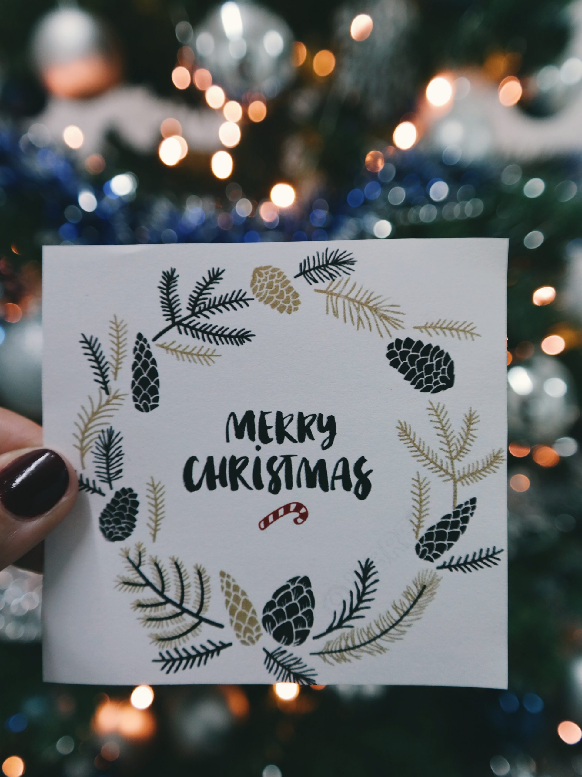 A wallpaper of a hand holding a Christmas greeting card