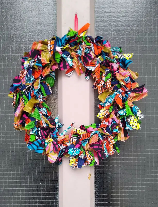 A homemade fabric colorful Christmas wreath on the front door