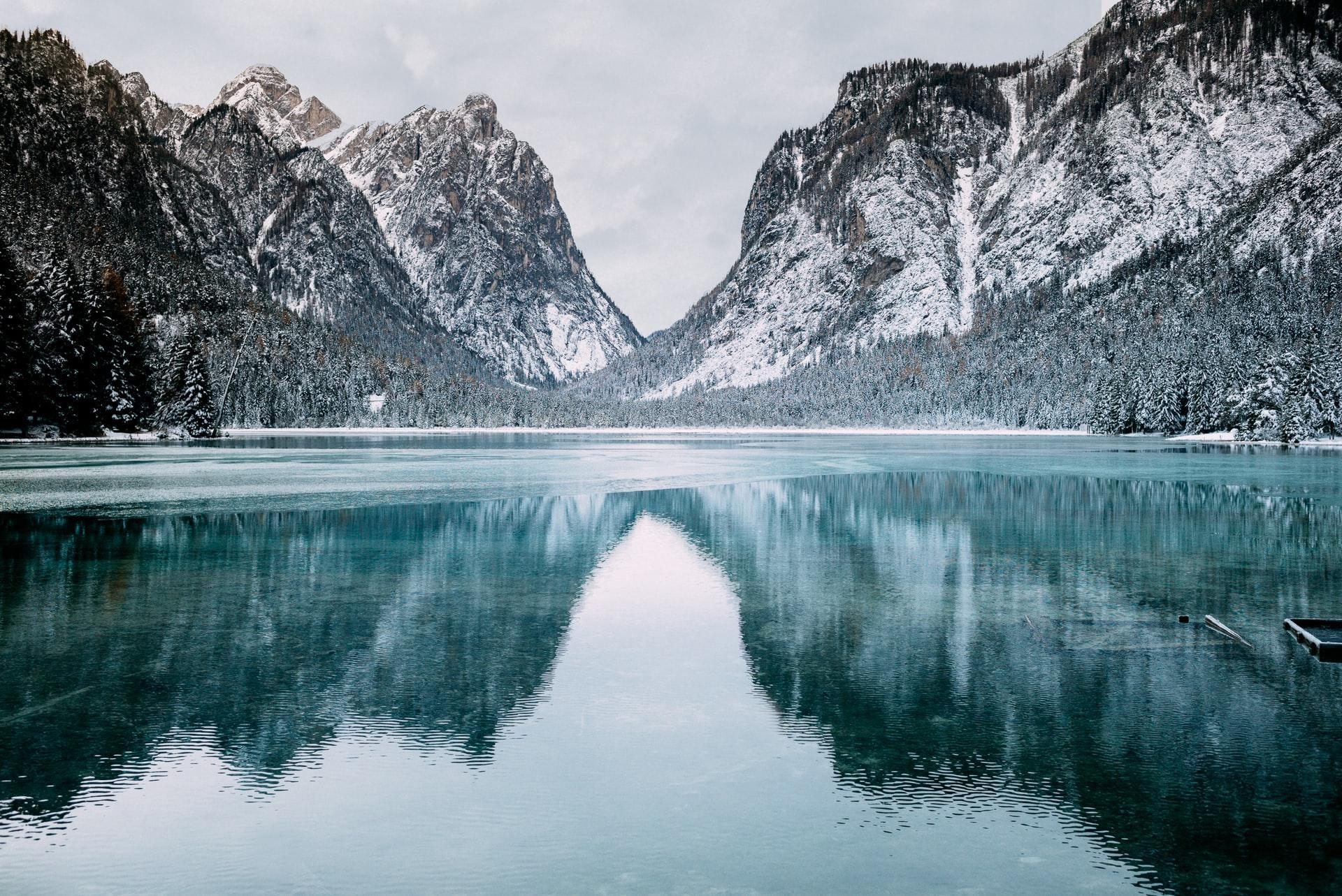 Lake surrounded by mountains A lake surrounded by mountains covered in patches of snow
