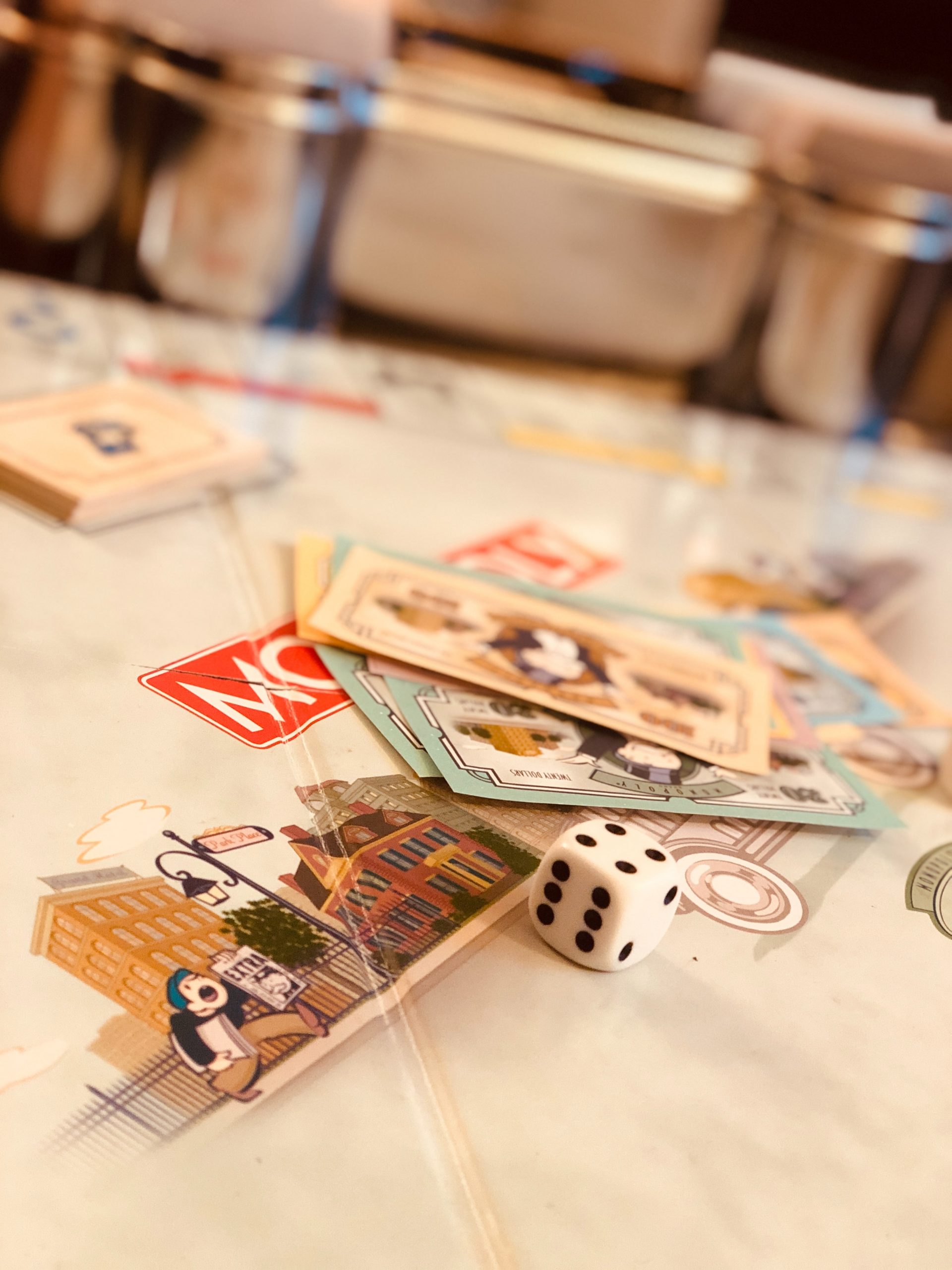 Monopoly game cards and dice Monopoly game board, cards, and dice on a table.