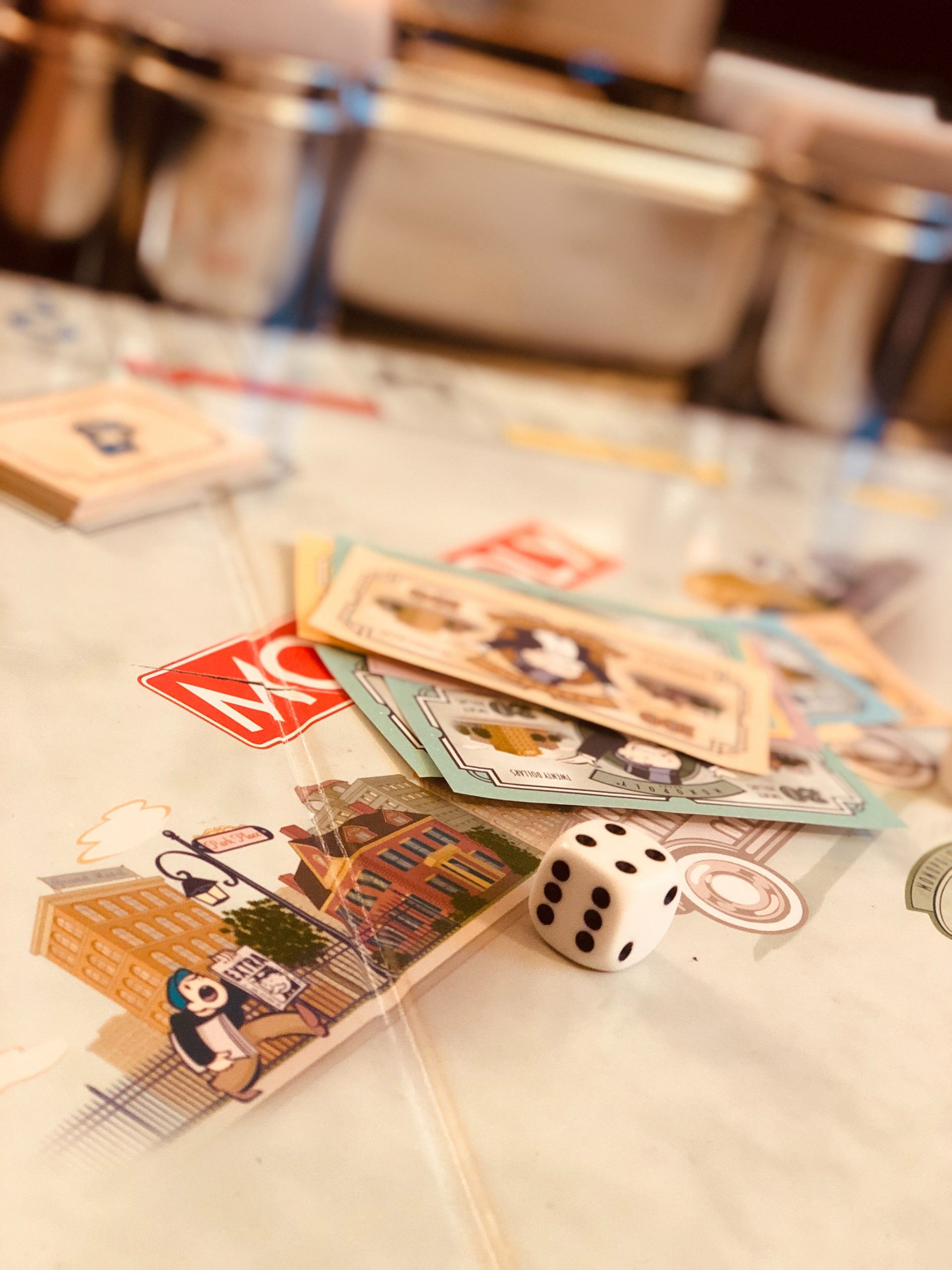 Monopoly game board, cards, and dice on a table.