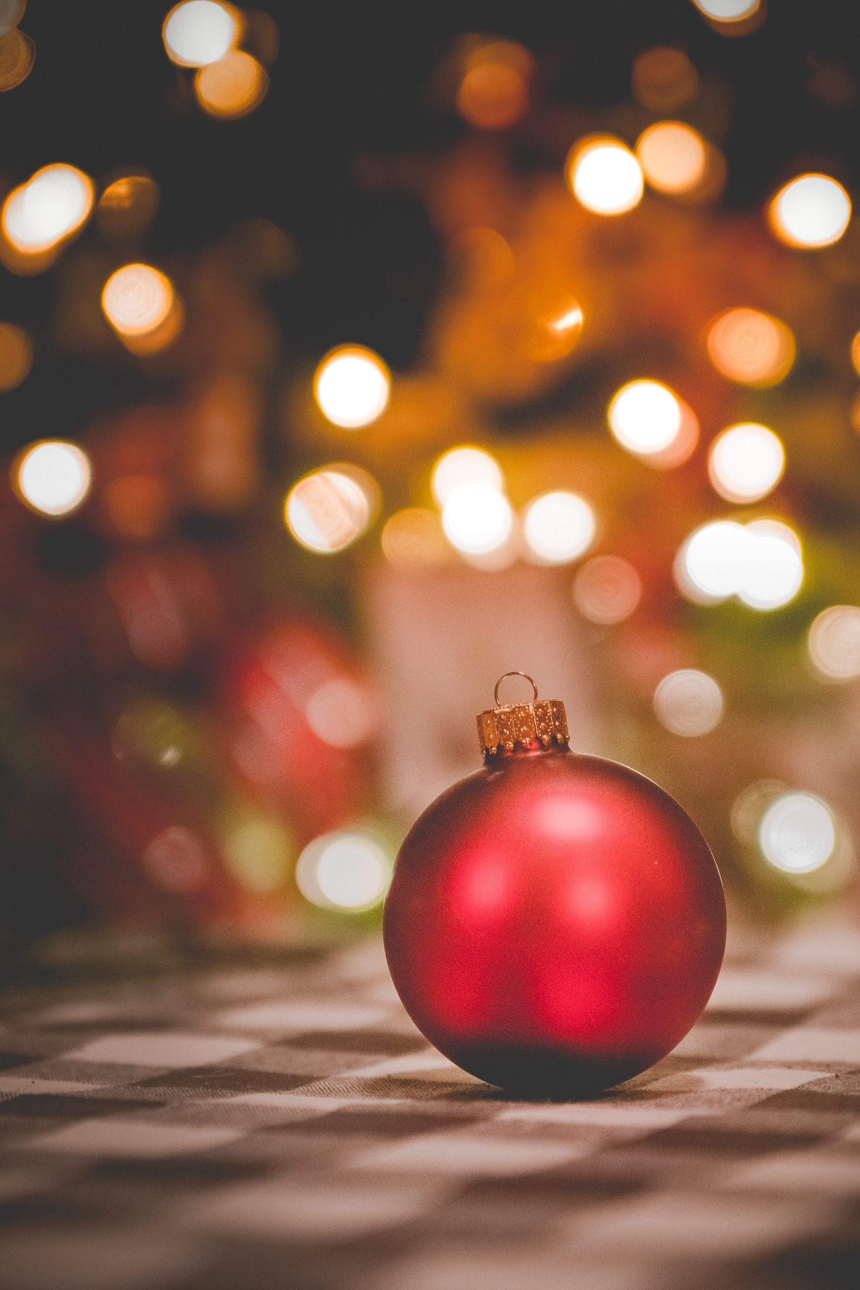 An iPhone wallpaper of a red bauble in focus with blurred background