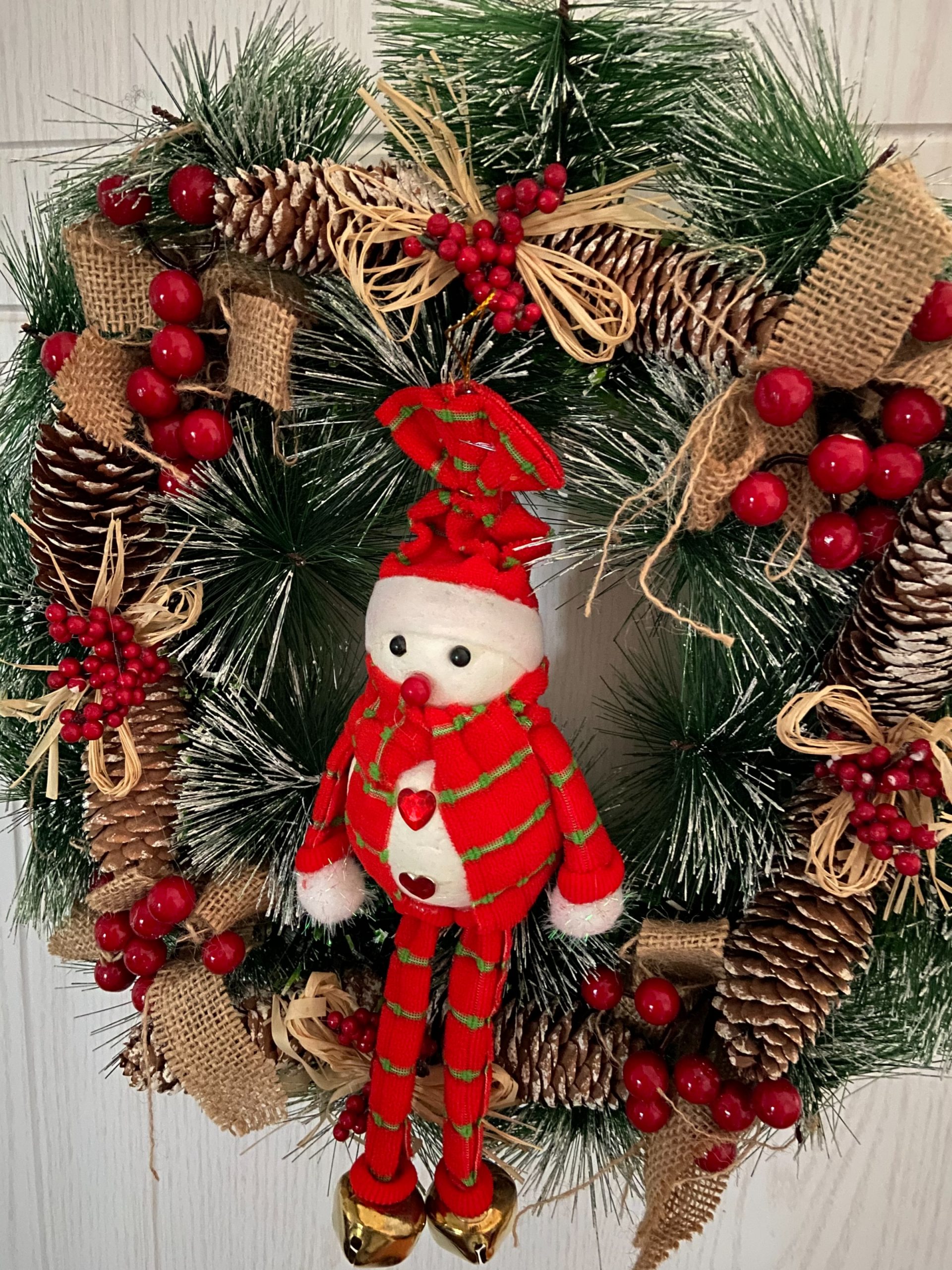 Red snowman hanging on a rustic christmas wreath