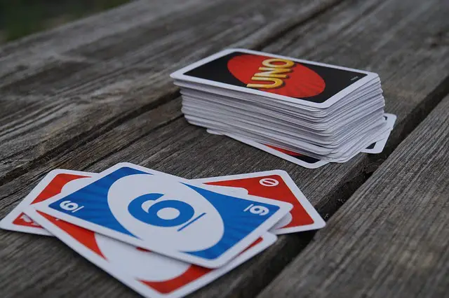 Uno cards piled up and some cards played Uno cards piled up and some cards played